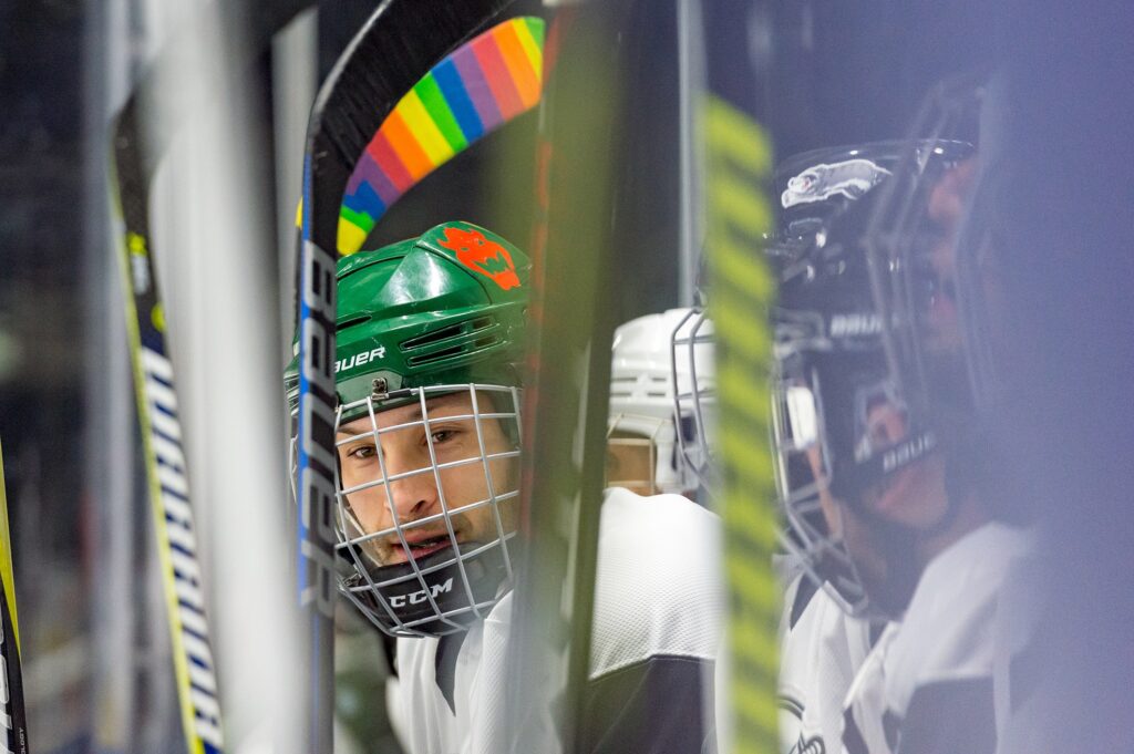 A player sitting on the bench, with a rainbow taped stick