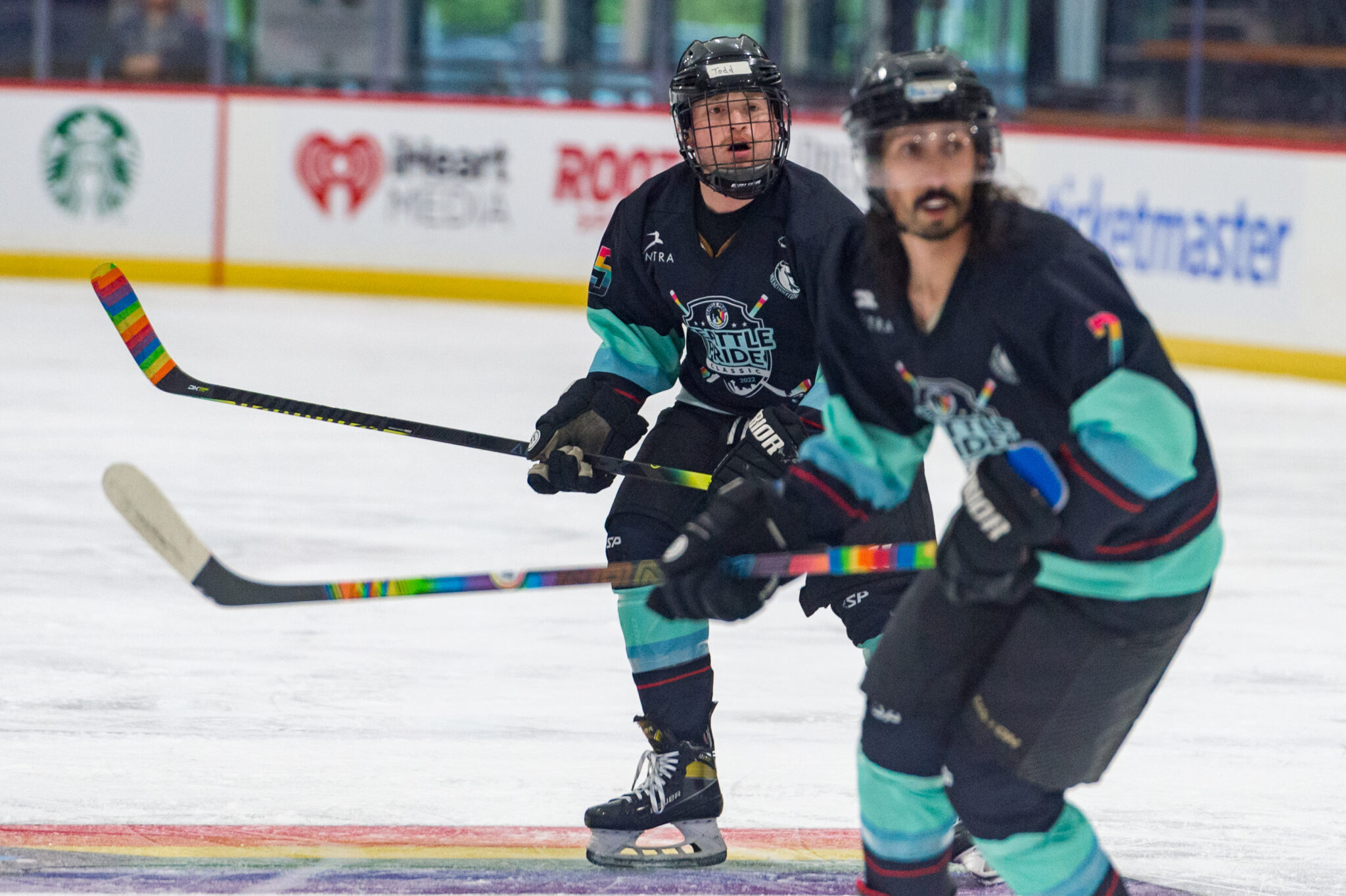 Two SPHA hockey players skating side by side on the ice.